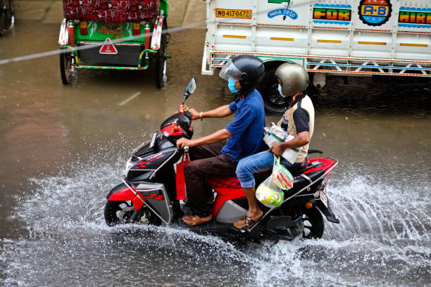 Kolkata Rain Flooding and people crossing inundated streets stock photo