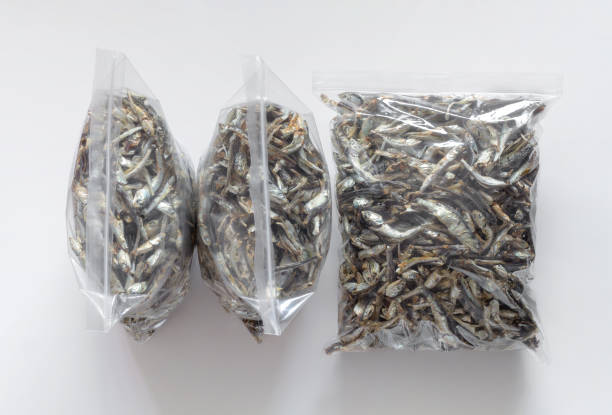 Anchoas secas coreanas en bolsas de plástico transparente con cremallera. Aislado sobre fondo blanco. Vista superior. Cómo almacenar anchoas en bolsas con cierre hermético en el refrigerador fotografías e imágenes de stock