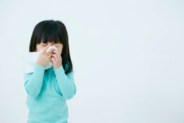 Korean girl blowing nose Korean girl blowing nose on white background child korea little girls korean ethnicity stock pictures, royalty-free photos & images