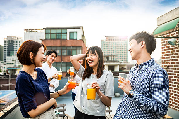 Korean people having rooftop party in Seoul Friends having fun and greetings together starting a rooftop party in Seoul - Hondae district. juices stock pictures, royalty-free photos & images