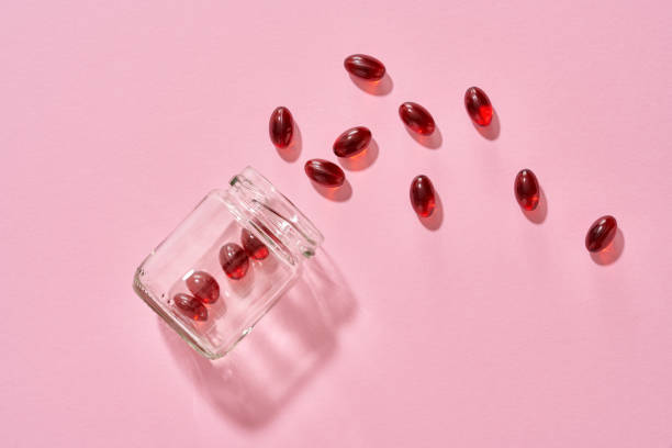 Krill oil pills or softgels on pink background stock photo