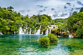 Beautiful Krka Waterfalls in Krka National Park, Croatia. Skradinski buk is the longest waterfall on the Krka River with clear turquoise water and dense forest. Long exposure for flowing water.
