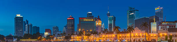 Kuala Lumpur downtown skyscrapers soaring over Merdeka Square illuminated landmarks Chrome blue dusk skies over the skyscrapers and landmarks of downtown Kuala Lumpur, with the iconic spires of the Petronas Towers and Menara Kuala Lumpur overlooking the historic domes of the Sultan Abdul Samad Building illuminated across the lawn of Merdeka Square, Malaysia. ProPhoto RGB profile for maximum color fidelity and gamut. bukit bintang stock pictures, royalty-free photos & images