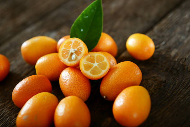 Kumquat fruits Kumquat fruits on old wooden table kumquat stock pictures, royalty-free photos & images
