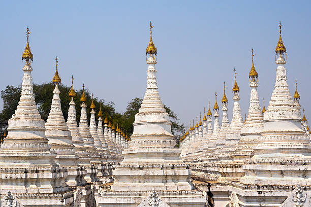 Kuthodaw Pagoda, the World's Largest Book, in Mandalay, Myanmar Some of the 729 stupas at Kuthodaw Pagoda, known as the world's largest book, in Mandalay, Myanmar. Each stupa contains a marble slab inscribed on both sides with a page of text from the Tipitaka, the entire Pali Canon of Theravada Buddhism. tipitaka stock pictures, royalty-free photos & images
