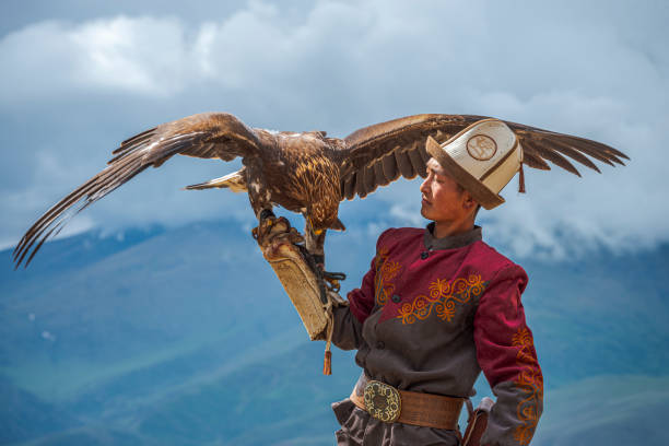 Kyrgyz Hunter  Eagle Traditional Kyrgyz Hunter Holding Eagle kazakhstan stock pictures, royalty-free photos & images
