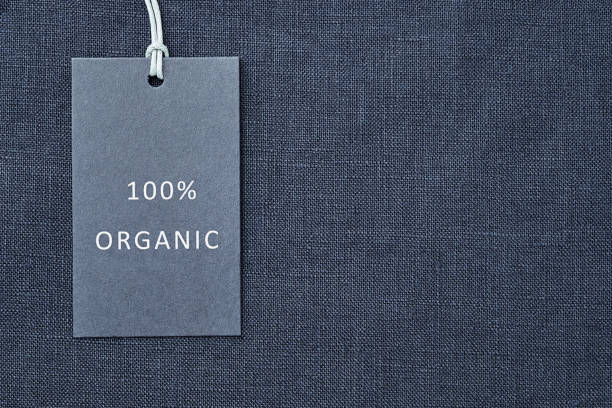 etikett auf leinen stoff hintergrund. 100% organische materal - sustainability fashion stock-fotos und bilder