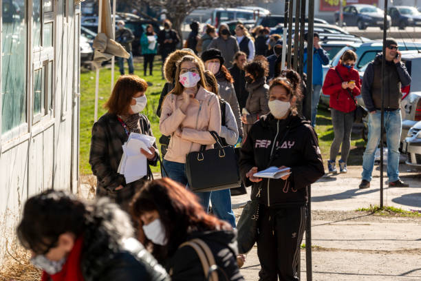 Labor bureau unemployment Sofia, Bulgaria - April 8, 2020: People wearing face masks in an attempt to prevent the spread of coronavirus disease COVID-19 wait in line in front of an office of the labor bureau. unemployment photos stock pictures, royalty-free photos & images