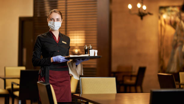 Lady in a mask tables at a fancy restaurant stock photo