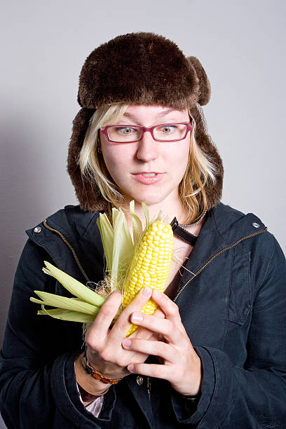 Lady of the Corn. A woman holding a corn cob who looks shocked or surprised. ugly skinny women stock pictures, royalty-free photos & images