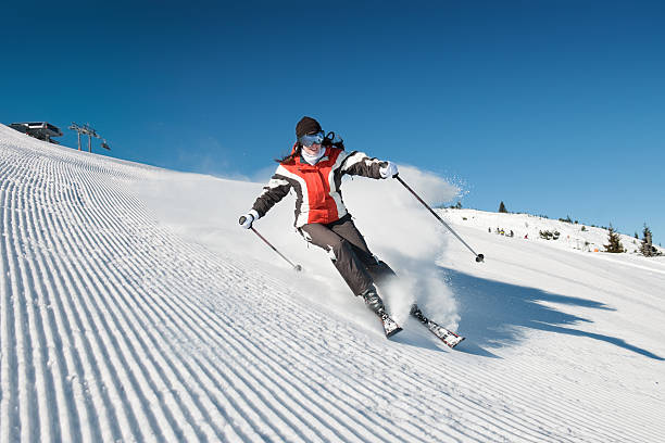 Lady skiing downslope on modified piste stock photo