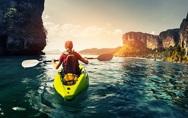 Lady with kayak Lady paddling the kayak in the calm tropical bay at sunset exotic asian girls stock pictures, royalty-free photos & images