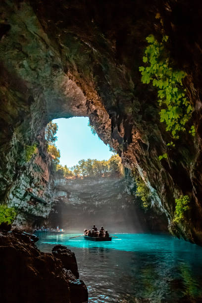 Lake Cave Melissani is a cave with its roof caved in many years ago. The cave in has caused water to come in and create a tepid lake. The colors are brilliant with the crystal clear waters. The open part of the cave gives you fantastic views from the boat all the way up to the sky. cave photos stock pictures, royalty-free photos & images