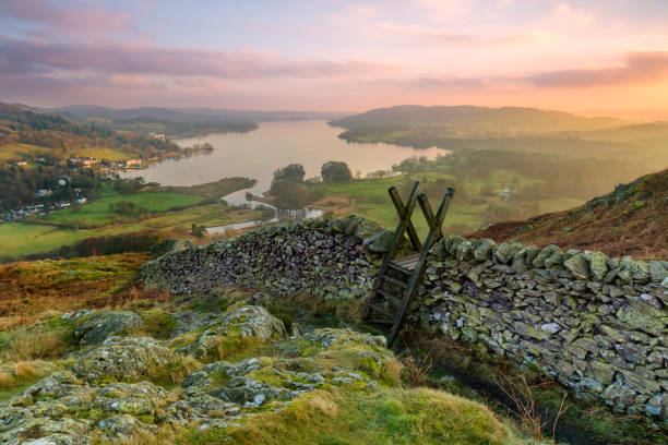 Lake District Winter Sunset. Beautiful sunset over Windermere in the Lake District with a stile and stone wall in the foreground. english lake district stock pictures, royalty-free photos & images
