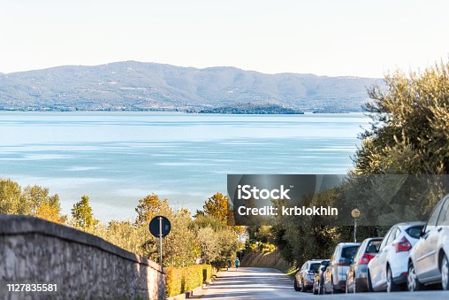 istock Lake Trasimeno high angle in Castiglione del Lago, Umbria, Italy landscape view of cars parked on street road during sunny summer day with nobody 1127835581
