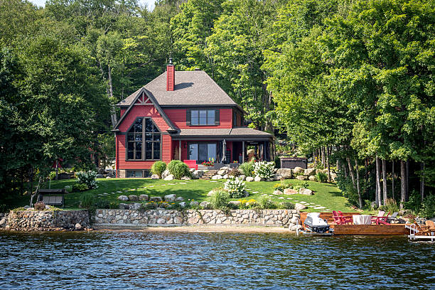 Lakefront Luxury Property on Sunny Day of Summer Lac St-Joseph, Сanada - August 18, 2015: Luxurious lakefront property located in Lac St-Joseph, a rich suburb of Quebec City on a sunny day of summer. cottage stock pictures, royalty-free photos & images