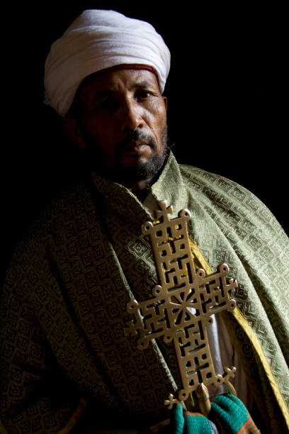 Lalibela priest and cross LALIBELA, ETHIOPIA - 23 AUGUST 2007 - A priets displays a golden cross. Each church in Ethiopia has its own cross that is solid gold and worth thousands of dollars. coptic christianity stock pictures, royalty-free photos & images