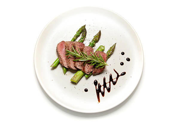 Lamb and Aparagus Filet of Lamb sliced on a bed of Asparagus with Balsamic Vinegar decoration fine dining stock pictures, royalty-free photos & images