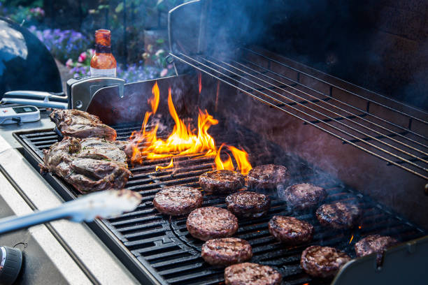 Lamb joint and burgers on a barbecue stock photo