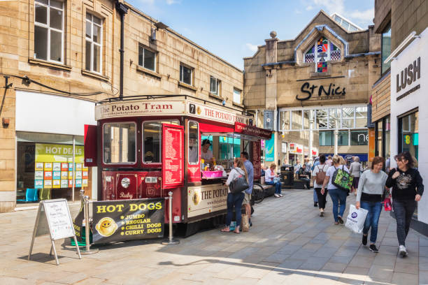 Lancaster, UK, Real People Shopping in Town Centre 12 July 2019: Lancaster, Lancashire, UK - The Potato Tram, an old tram converted to sell jacket potatoes, outside St Nic's Arcade in the town centre. Shoppers passing by. lancaster lancashire stock pictures, royalty-free photos & images