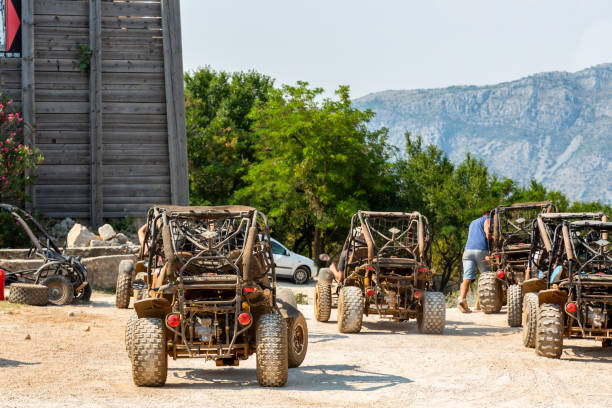 Landscape back view of several dune buggy vehicles and incidental people. stock photo