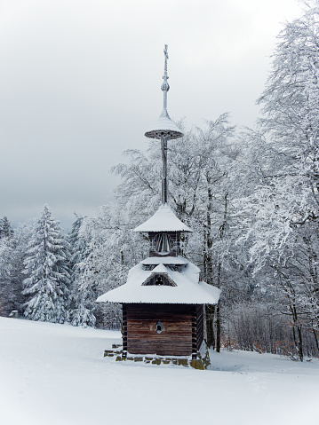 Landscape from Beskydy mountains, typical Wallachian wood chapel architecture in Pustevny near Radhost, Moravia Czech republic during snowy winter time, cold and white snow.