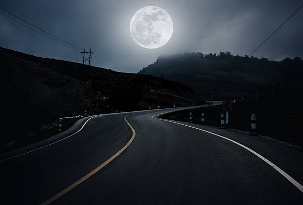landscape of nighttime with curvy roadway in forest at national - moon b&w imagens e fotografias de stock
