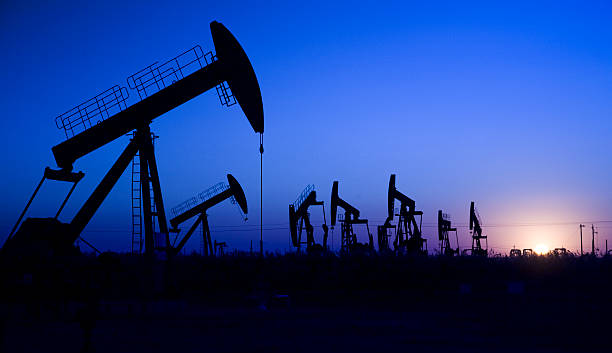landscape of oil well silhouette stock photo