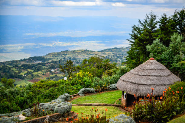 Landscape view from Kerio Escarpment, of traditional African Banda with thatched roof overlooking the Great Rift Valley. stock photo