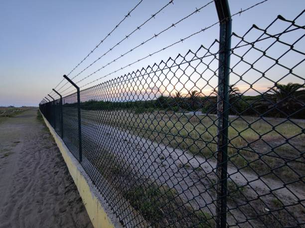 landscape with barbed wire /fence - prision imagens e fotografias de stock