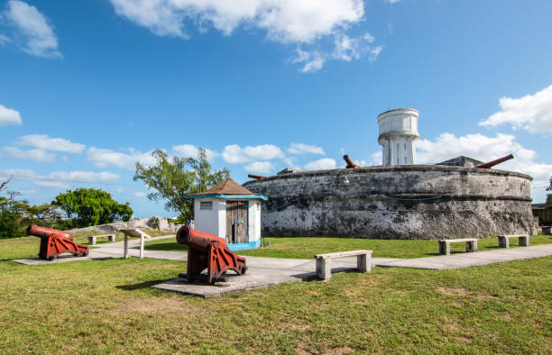 Landscape with Fort Fincastle and old cannons. New Providence, Nassau, Bahamas Colorful image with old fort, medieval cannons, green lawn and water tower in the background. Blue sky and white clouds. fort stock pictures, royalty-free photos & images