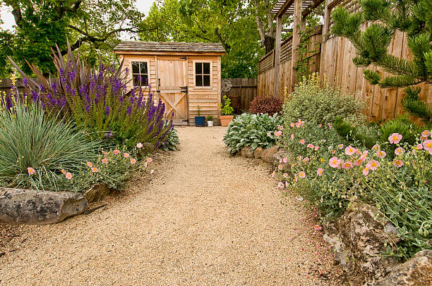 landscaped yard beautifully landscaped backyard with small wooden shed, fence and pathway garden path stock pictures, royalty-free photos & images