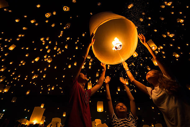 Lantern Thai's Family release sky lanterns to worship buddha's relics in yi peng festival, Chiangmai thailand lantern stock pictures, royalty-free photos & images
