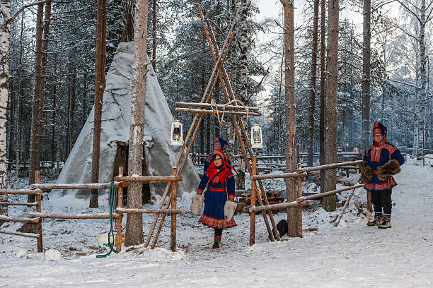 Lapland (Finland). Two Sami people near their “lavvu” stock photo