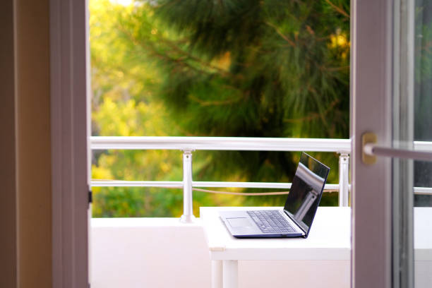 Laptop computer on the balcony table. Home office. stock photo