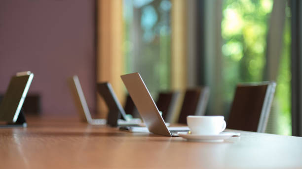 Laptop computer stand on wooden meeting table Laptop computer stand on wooden meeting table in modern board room board room stock pictures, royalty-free photos & images