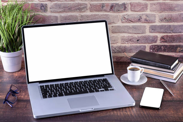 Laptop notebook with blank screen and smartphone on desk stock photo