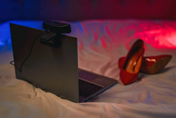 laptop with webcam on the bed. adult webcam work concept. - video chat porn 個照片及圖片檔