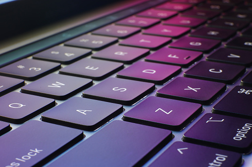 closeup of keyboard with puple and colorful background, technology and information