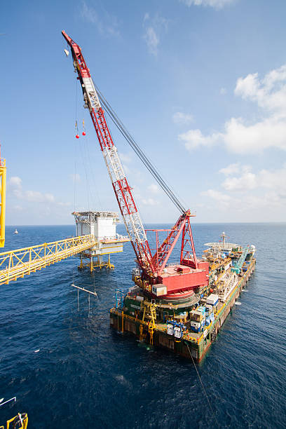 Large crane vessel installing the platform in offshore Large crane vessel installing the platform in offshore,crane barge doing marine heavy lift installation works in the gulf or the sea Power animated fishing lure stock pictures, royalty-free photos & images