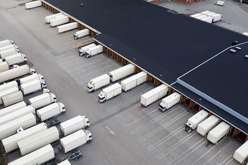Aerial view of a large distribution warehouse loading dock with many trucks outside.