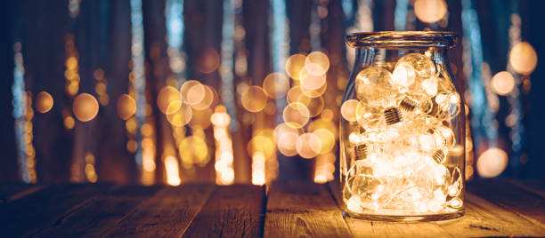 Large glass jar with light bulbs, Christmas lights and bokeh stock photo