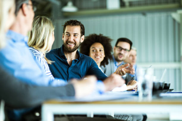 Large group of happy business colleagues talking on a meeting in the office. stock photo