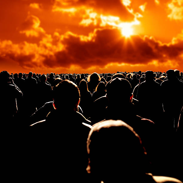 large group of people close up shot of people walking on busy street during sunset. apocalypse stock pictures, royalty-free photos & images