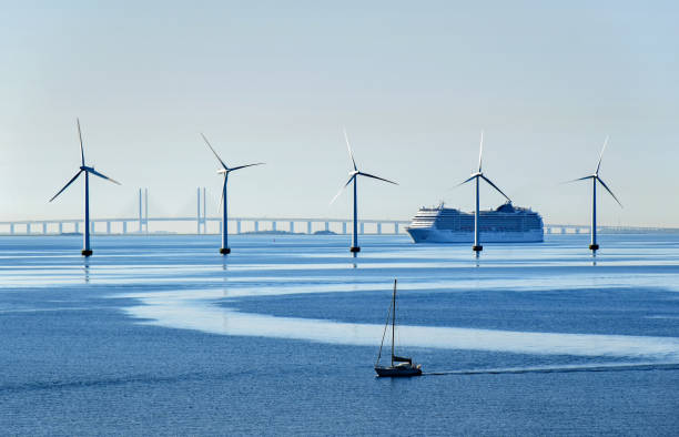 paquebot grand et un petit voilier passent des éoliennes en pleine mer près du pont de l’øresund entre le danemark et la suède - transition énergétique photos et images de collection
