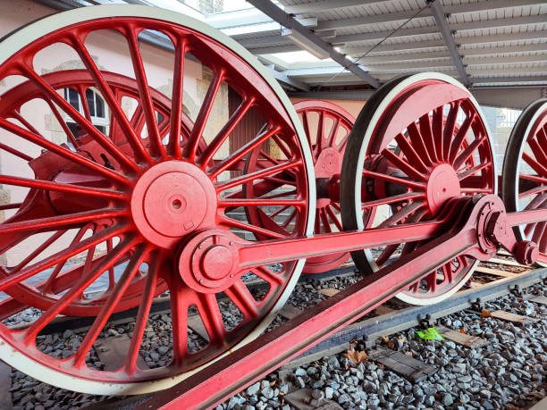 Large red wheels of a railroad steam locomotive with connecting rods stock photo