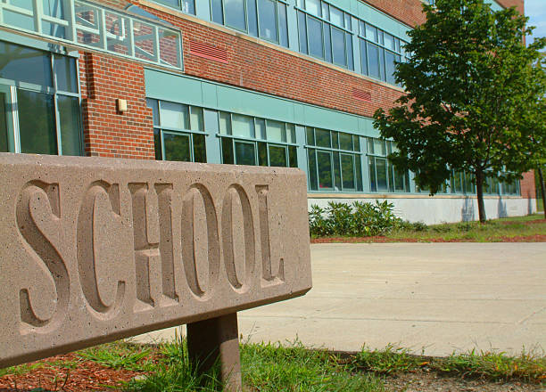 Large School sign in front of school building Front of school building in the morning, waiting for students to arrive. school exteriors stock pictures, royalty-free photos & images