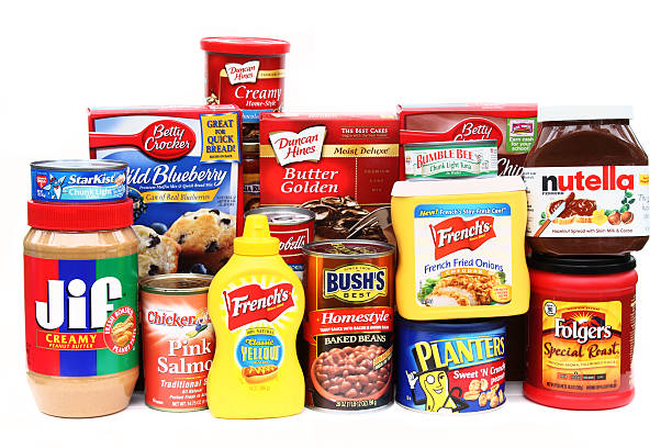 Large selection of brand name groceries West Palm Beach, USA - October 28, 2011: This is a studio product shot of a large selection of brand name groceries. In full view are Star Kist tuna, Jif peanut butter, Chicken of the Sea salmon and tuna, Bushs baked beans, Planters peanuts, Frenchs mustard and fried onions, Folgers coffee, and Nutella cocoa spread. Other products are partially visible in the background. This is a collection of some of the basic staples found in many American kitchens. jif stock pictures, royalty-free photos & images