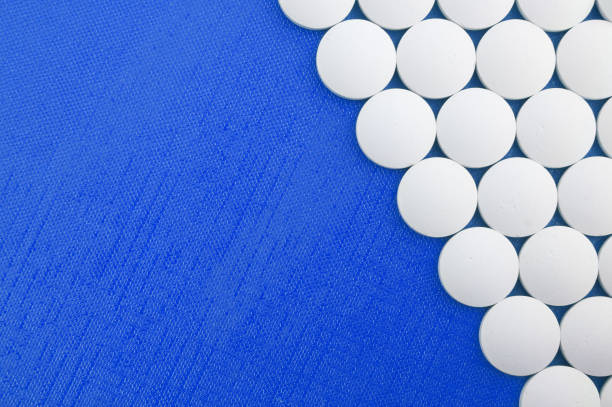 Large white pills on blue background stock photo