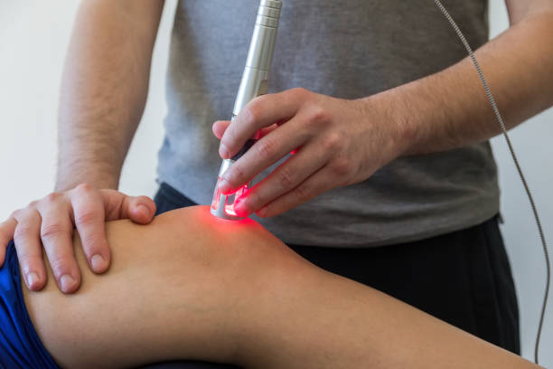 Laser therapy on a knee used to treat pain stock photo